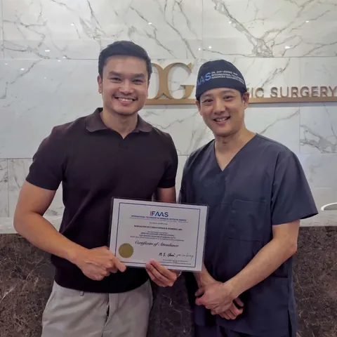 Dr. Romero holding a training certificate with a surgeon abroad