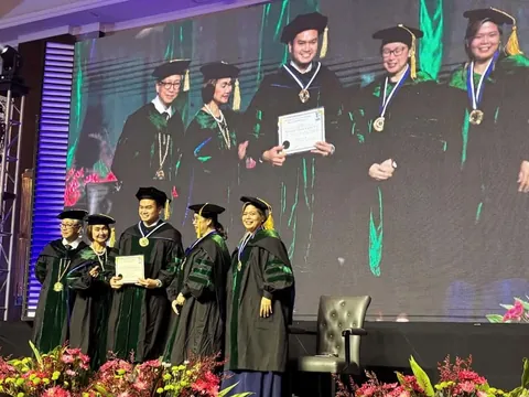 Dr. Romero receiving his certificate on stage at a conferment ceremony
