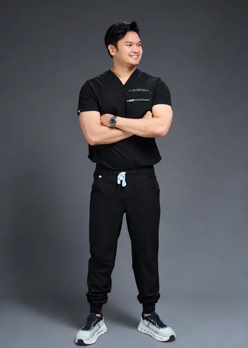 Dr. Ken Romero in black scrubs, arms crossed