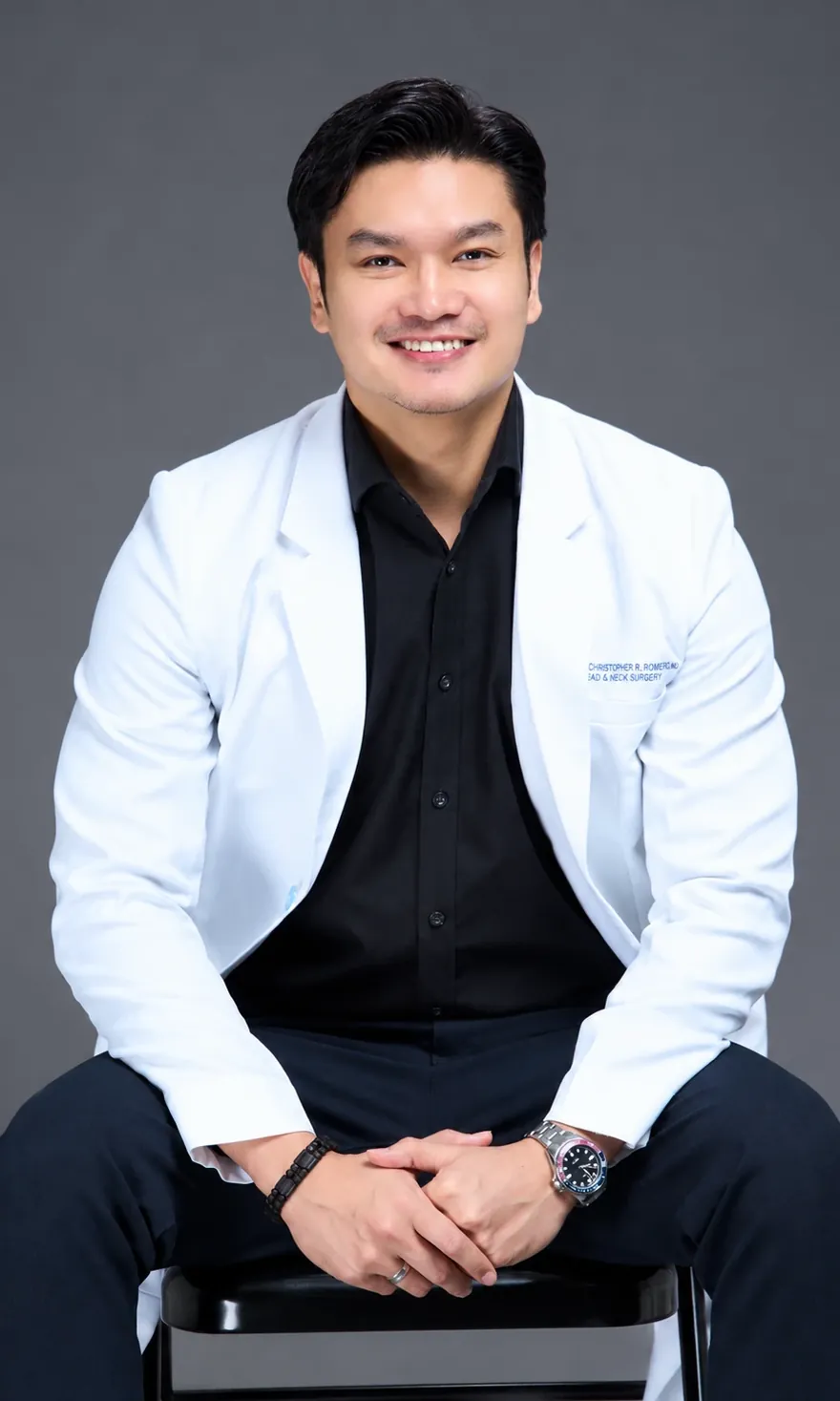 Dr. Ken Romero seated, in a white physician's coat